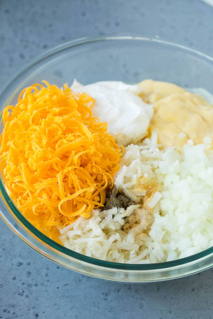 Hash Brown Casserole | Potato Casserole | Hash Brown Side Dish #potatoes #cheese #casserole #sidedish #edsug A bowl of potato shreds, cheese, cream of chicken soup, sour cream and seasonings.
