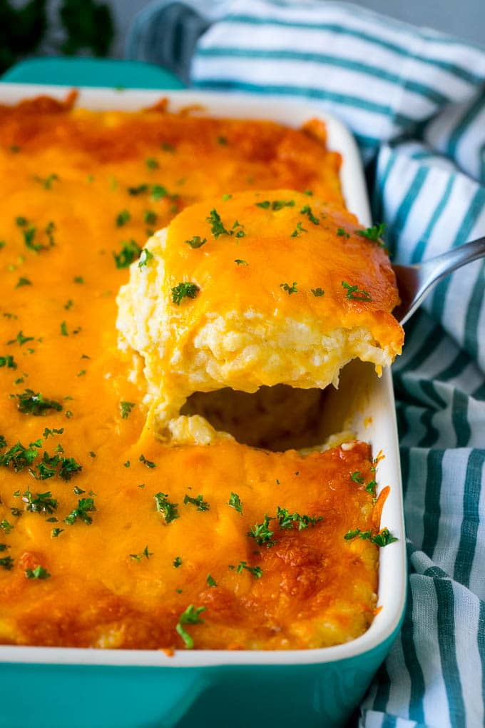 Hash Brown Casserole | Potato Casserole | Hash Brown Side Dish #potatoes #cheese #casserole #sidedish #edsug A spatula pulling out a serving of cheesy hash brown casserole.