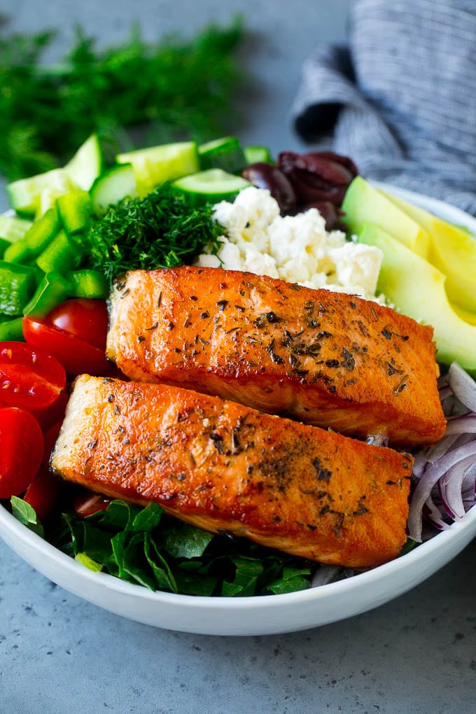 Greek Salmon Salad Recipe | Low Carb Salmon Recipe | Salmon Salad #salmon #seafood #fish #lowcarb #keto #lunch #edsug #healthy Salmon fillets on lettuce with tomatoes, feta cheese, avocado, olives, cucumbers and herbs.