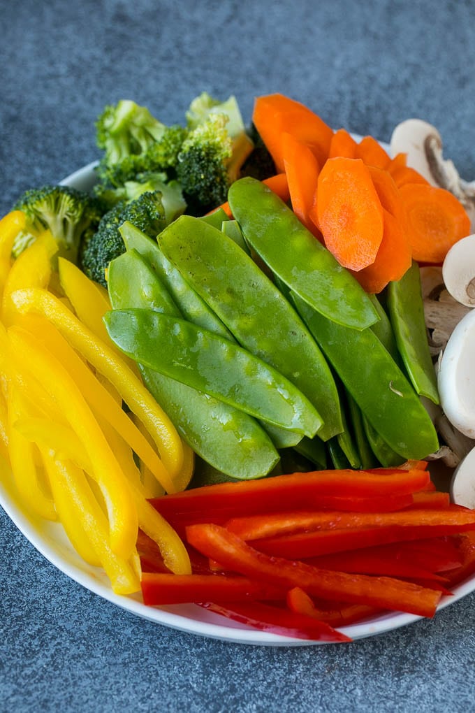 Vegetable Stir Fry Recipe | Veggie Stir Fry | Broccoli Stir Fry #vegetarian #vegetables #broccoli #dinner #edsug Bell peppers, snow peas, carrots, mushrooms and broccoli on a plate.