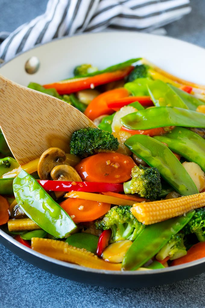 Vegetable Stir Fry Recipe | Veggie Stir Fry | Broccoli Stir Fry #vegetarian #vegetables #broccoli #dinner #edsug A spatula in a pan of veggie stir fry with carrots, snow peas and broccoli.