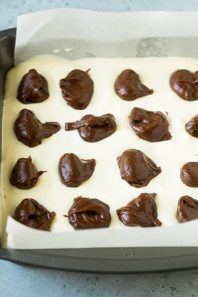 Cheesecake Brownies Recipe | Cream Cheese Brownies | Homemade Brownies #brownies #cheesecake #chocolate #dessert #edsug Brownies topped with a layer of cheesecake and dollops of chocolate batter.