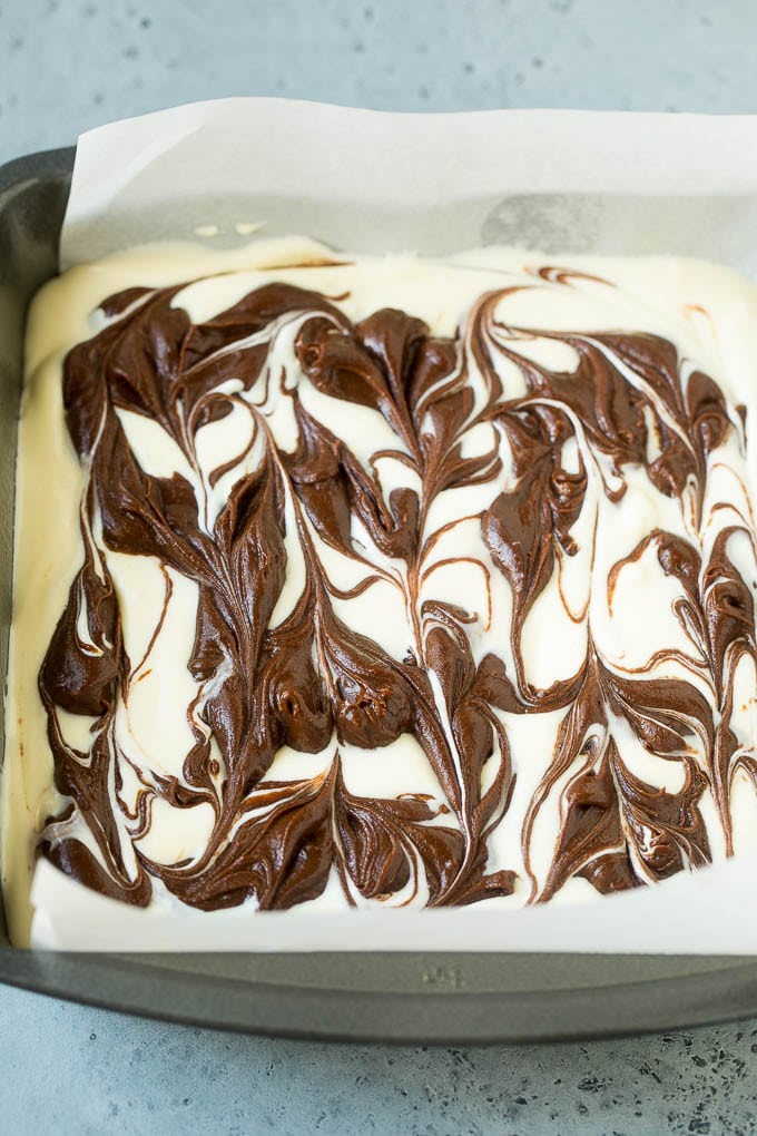 Cheesecake Brownies Recipe | Cream Cheese Brownies | Homemade Brownies #brownies #cheesecake #chocolate #dessert #edsug Swirled chocolate and cream cheese brownie batters in a baking pan.