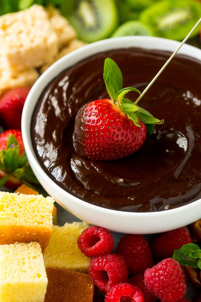 Chocolate Fondue Recipe | Chocolate Sauce | Chocolate Dip #chocolate #dessert #glutenfree #fondue #edsug A strawberry being dipped into a bowl of fondue.