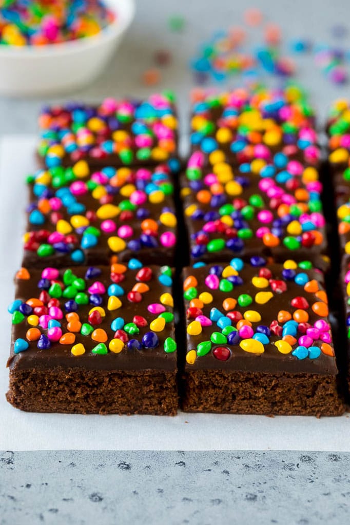 Cosmic Brownies Recipe | Cocoa Brownies | Frosted Brownies #brownies #chocolate #dessert #edsug #sprinkles Cosmic brownies topped with chocolate fudge and crunchy rainbow sprinkles.