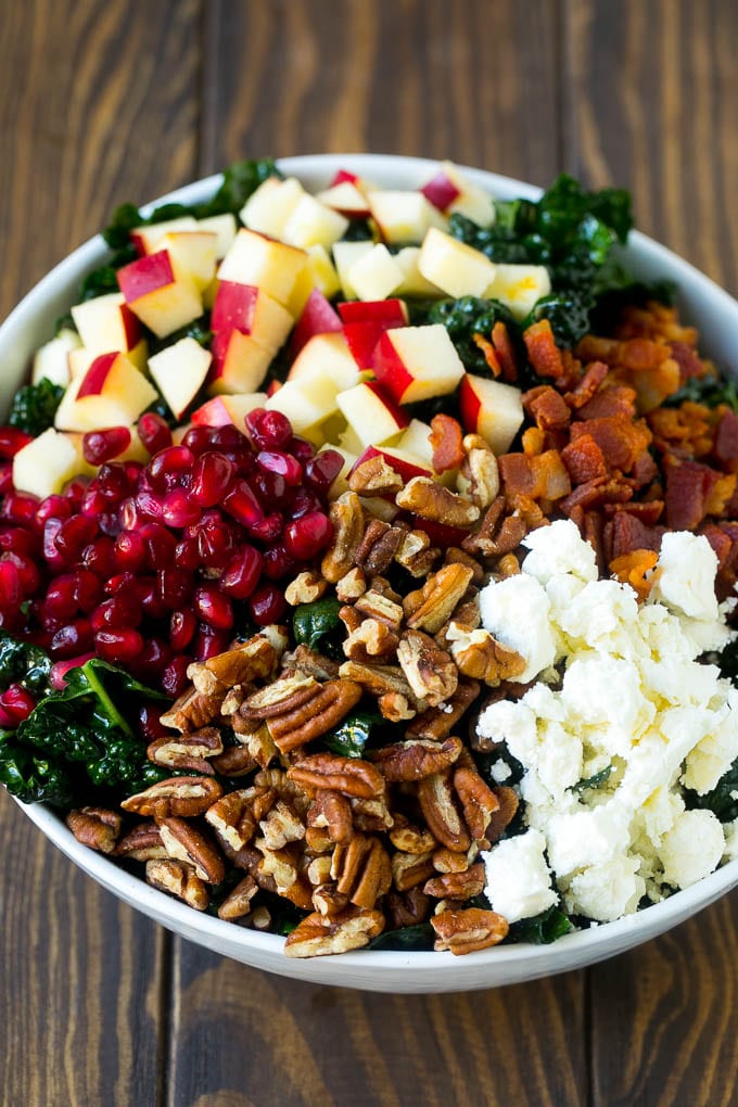 Apple Kale Salad Recipe | Kale Recipe | Fall Salad #kale #apples #bacon #salad #feta #dinner #lunch #edsug Kale salad topped with apples, bacon, pecans, pomegranate and feta cheese.