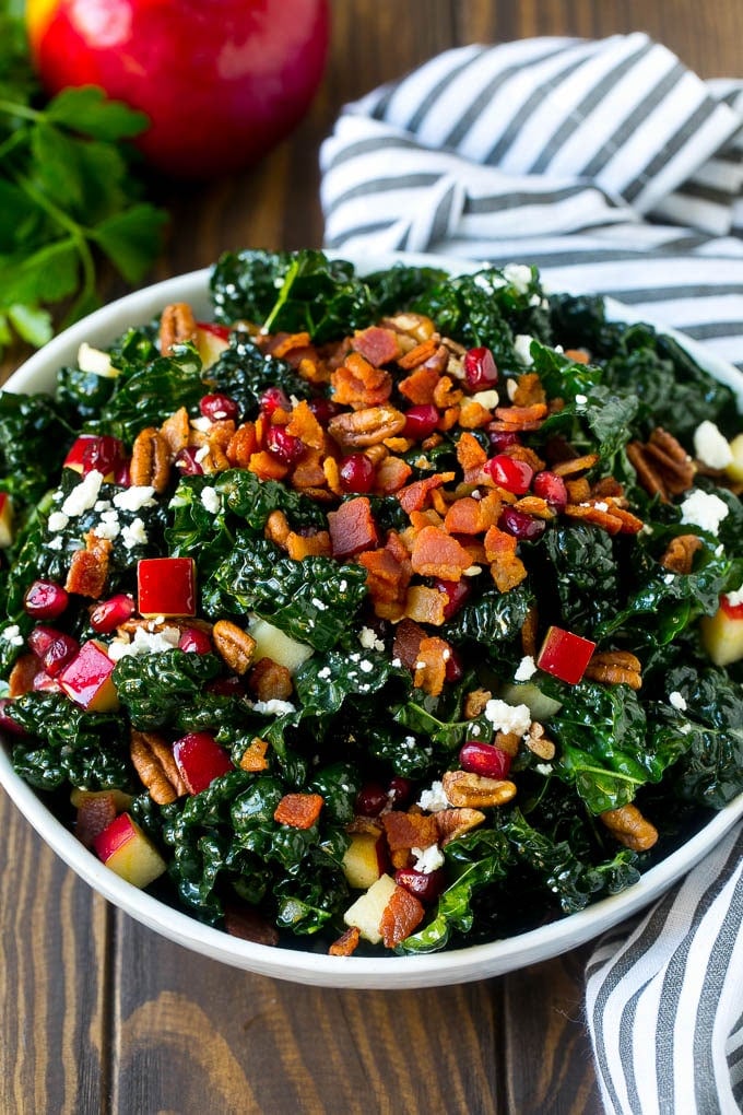 Apple Kale Salad Recipe | Kale Recipe | Fall Salad #kale #apples #bacon #salad #feta #dinner #lunch #edsug A bowl of tuscan kale salad garnished with cooked bacon.