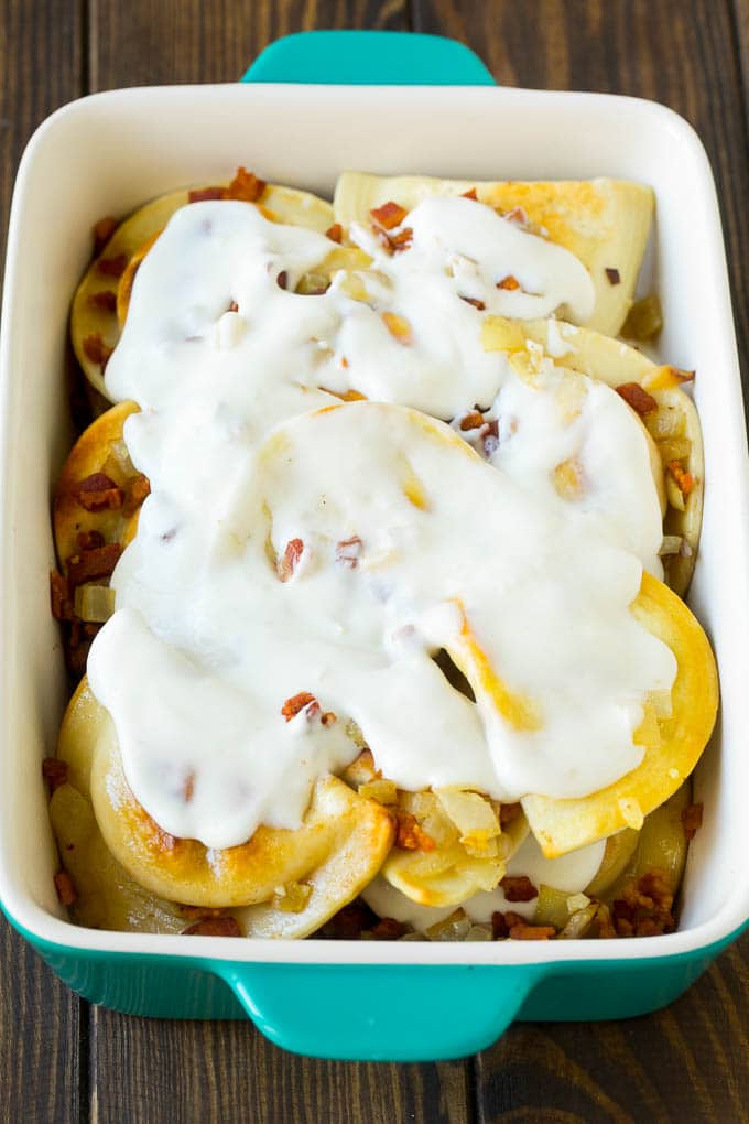 Pierogi Casserole Recipe | Potato Casserole #pierogis #casserole #bacon #cheddar #dinner #edsug Dumplings in a baking dish covered with creamy sauce.