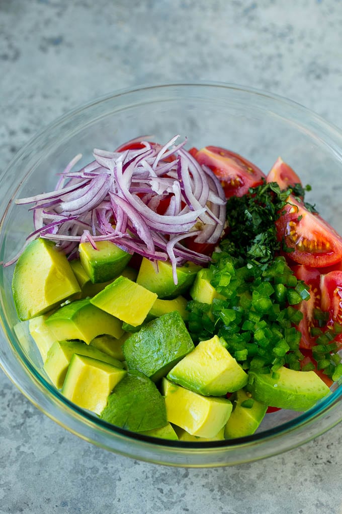 Tomato Avocado Salad Recipe | Avocado Salad | Tomato Salad #salad #tomato #avocado #glutenfree #cleaneating #dinner #edsug #healthy Pieces of avocado, tomato, red onion and minced jalapeno in a salad bowl.