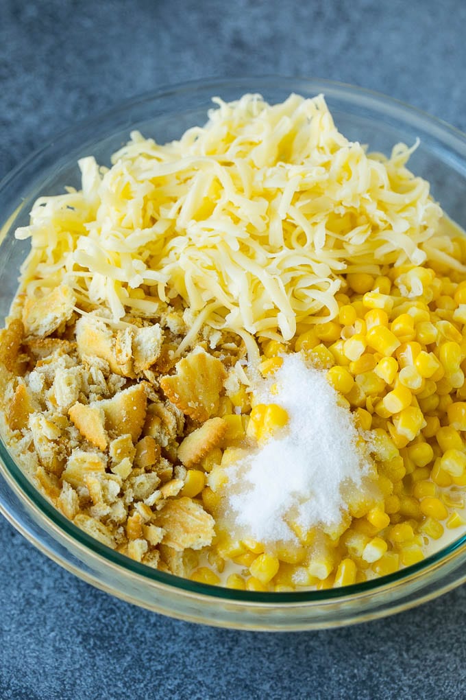 Scalloped Corn | Corn Casserole #corn #casserole #cheese #sidedish #dinner #edsug Corn, crushed crackers, seasonings and shredded cheese in a bowl.