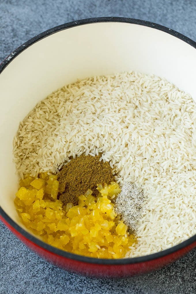 Black Beans and Rice Recipe | Cuban Black Beans | Beans and Rice #beans #rice #blackbeans #sidedish #glutenfree #dinner #edsug Onions, garlic, white rice and spices in a pot.