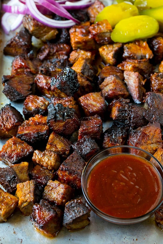 Burnt Ends Recipe | Smoked Brisket | Beef Brisket #brisket #bbq #smoker #beef #dinner #edsug Burnt ends on a sheet pan served with BBQ sauce, red onions and pickles.