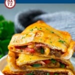 This homemade calzone recipe is a mixture of sausage, pepperoni and bell peppers, all baked inside pizza dough with plenty of melted cheese.