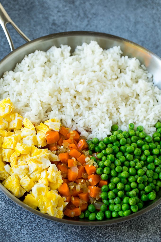 Chicken Fried Rice Recipe | Chinese Fried Rice #rice #chicken #peas #carrots #sidedish #dinner #edsug A pan of cooked rice, carrots, eggs and peas.