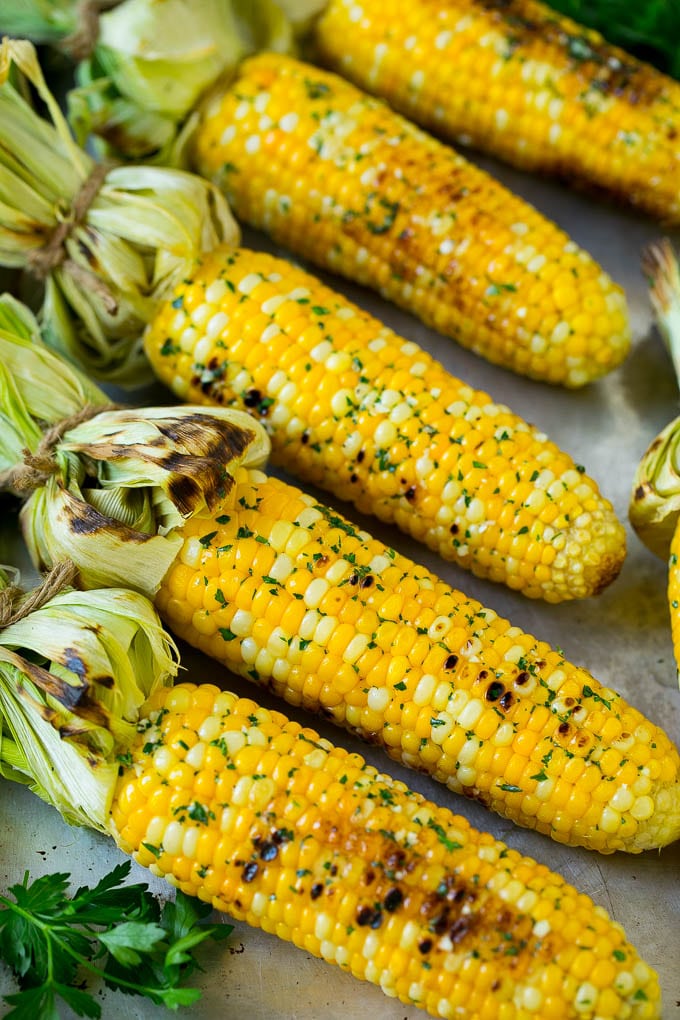Grilled Corn on the Cob Recipe | Corn Recipe #corn #grilling #summer #sidedish #dinner #edsug Grilled corn on the cob topped with garlic and herb butter on a sheet pan.