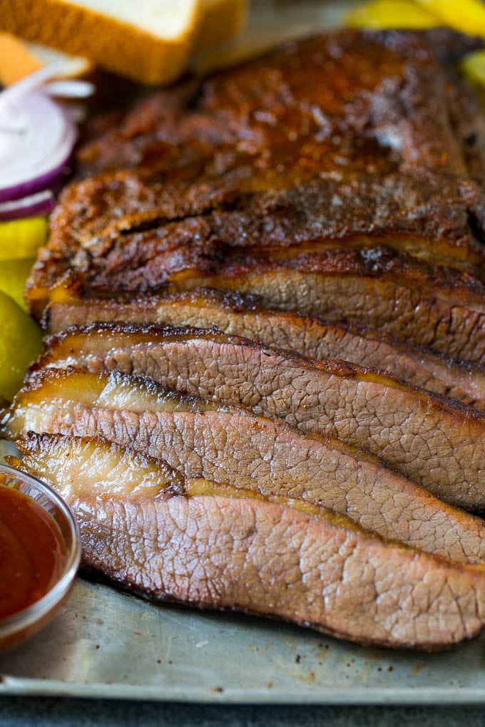 Smoked Brisket Recipe | Beef Brisket | BBQ Beef #brisket #smoker #beef #bbq #dinner #edsug Sliced smoked brisket with a side of BBQ sauce.