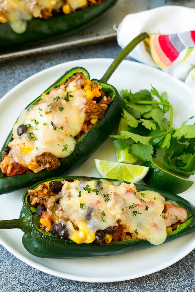 Stuffed Poblano Peppers | Stuffed Peppers | Pasilla Peppers #peppers #stuffedpeppers #beef #rice #beans #corn #dinner #edsug A plate of stuffed poblano peppers topped with melted cheese.