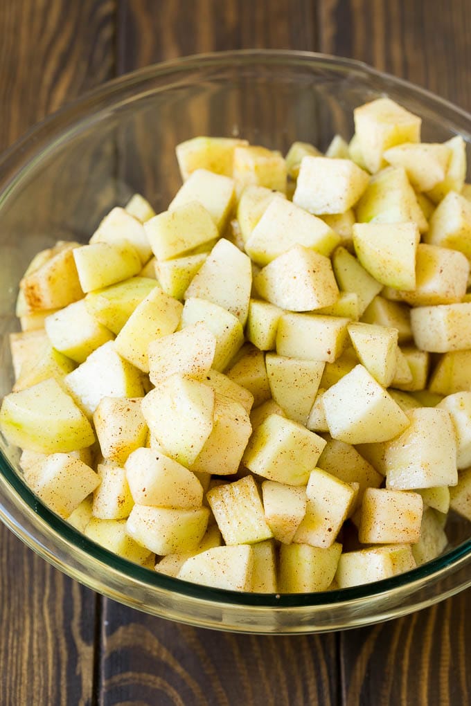 Apple Crisp Recipe | Apple Dessert #apples #dessert #baking #fall #edsug Diced apples tossed with sugar and cinnamon in a bowl.
