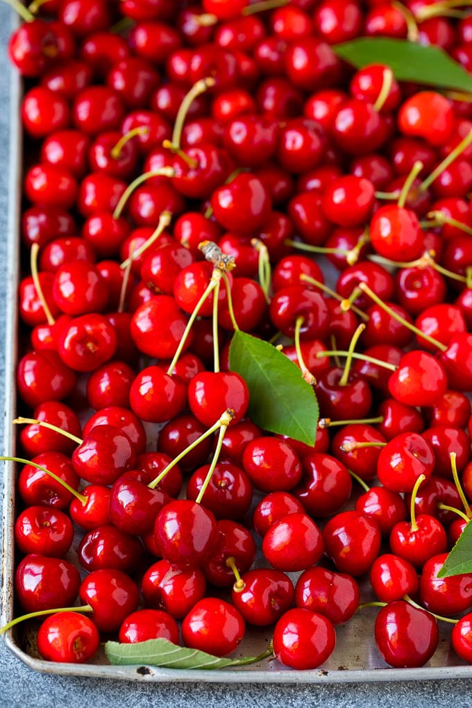 Cherry Pie Filling Recipe #pie #cherries #dessert #sweets #edsug #summer Fresh cherries spread out on a sheet pan.
