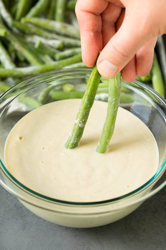 Fried Green Beans Recipe | Green Beans #greenbeans #appetizer #snack #edsug A hand dipping beans into beer batter.