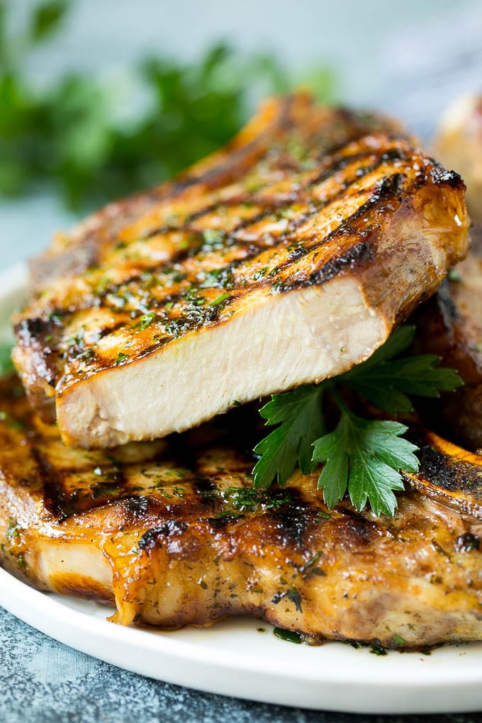 Grilled Pork Chops | Pork Chop Marinade #porkchops #grilling #pork #marinade #dinner #edsug Grilled pork chops with a cut chop on top of the stack.