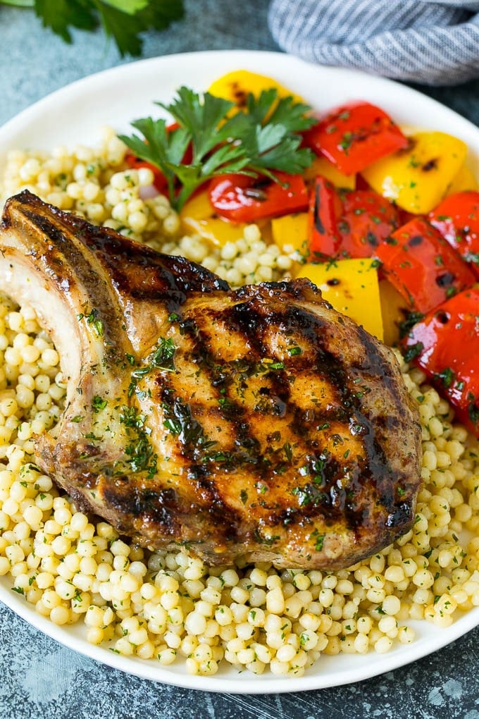 Grilled Pork Chops | Pork Chop Marinade #porkchops #grilling #pork #marinade #dinner #edsug A grilled pork chop served over couscous with bell peppers on the side.