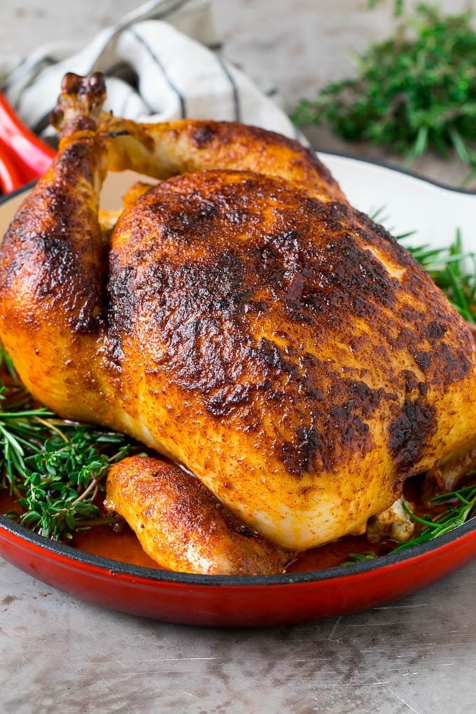 Rotisserie Chicken Recipe | Roasted Chicken #chicken #dinner #edsug #comfortfood Rotisserie chicken in a skillet garnished with fresh herbs.