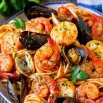 A bowl of seafood pasta with shrimp, clams and scallops.