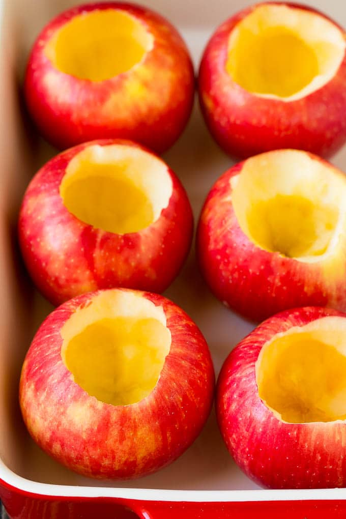 Baked Apples | Stuffed Apples #apples #fall #dessert #sweettooth #edsug Hollowed out apples in a baking dish.