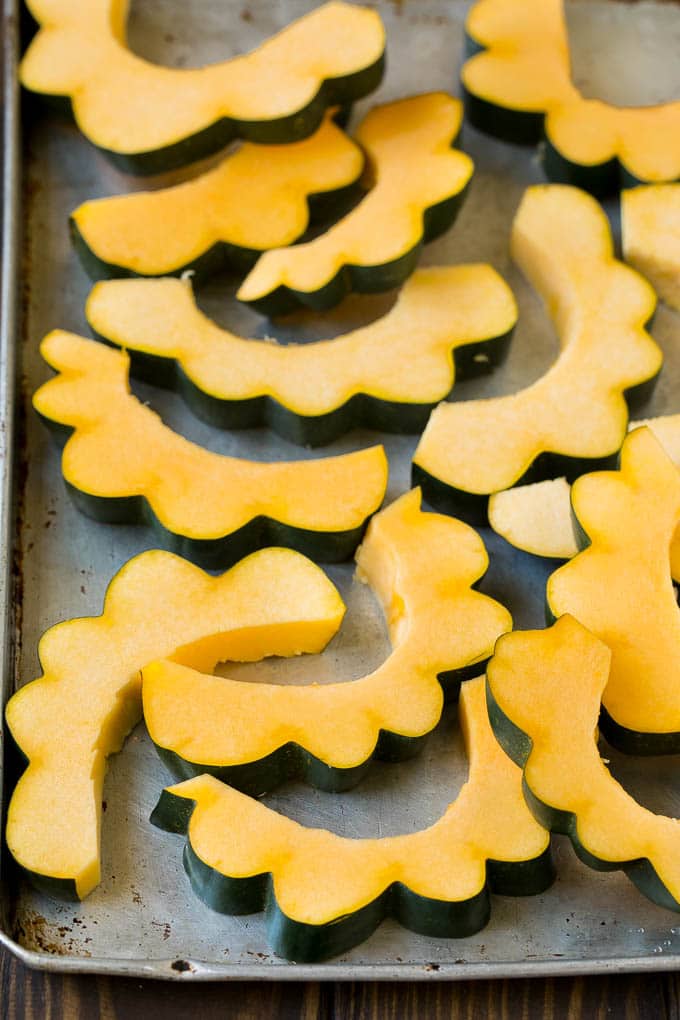 Roasted Acorn Squash | Acorn Squash Recipe #squash #winter #sidedish #dinner #edsug Sliced acorn squash on a sheet pan.