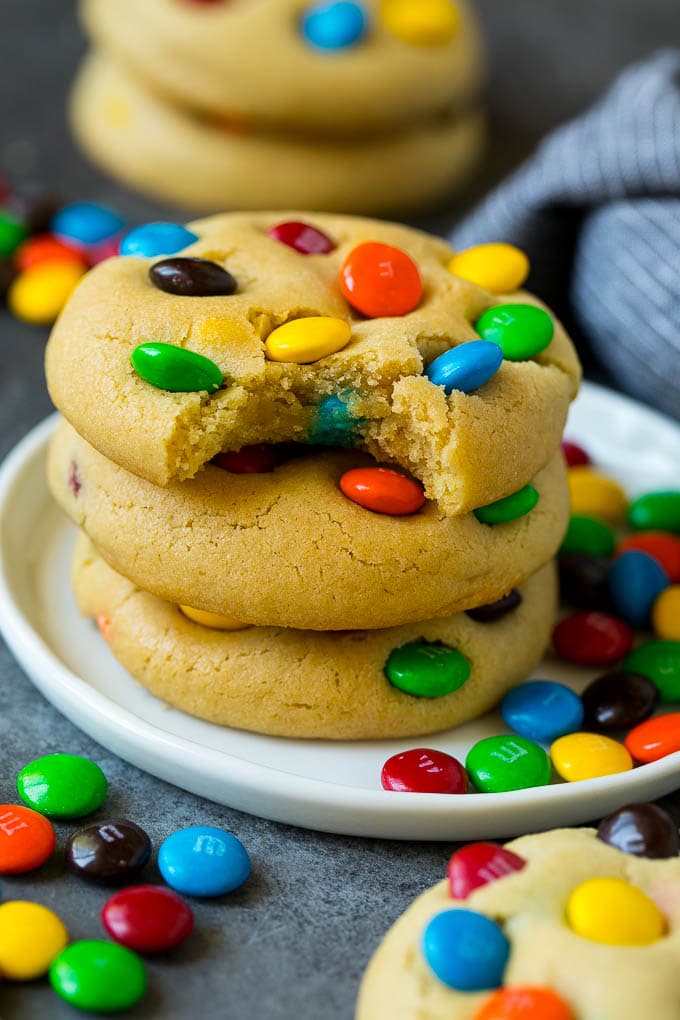 M&M Cookies Recipe #cookies #chocolate #baking #dessert #sweets #edsug A stack of M&M cookies with a bite taken out of one.
