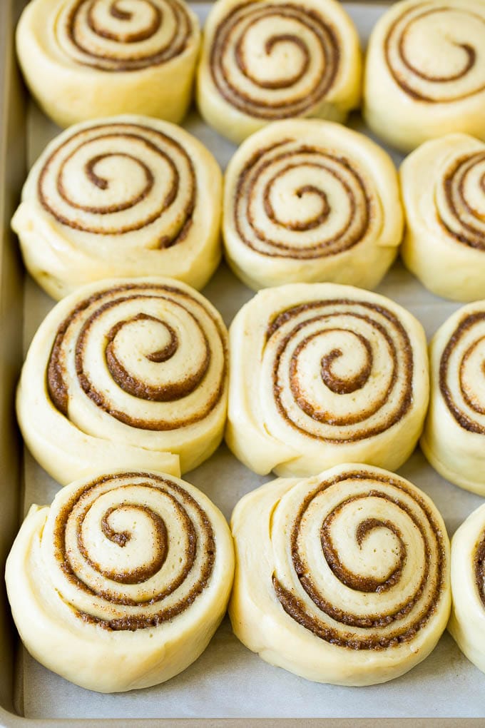 Cinnamon Rolls Recipe | Cinnamon Buns #cinnamon #rolls #pastry #breakfast #brunch #sweets #edsug #baking #bread Rolls of dough and filling rising on a sheet pan.