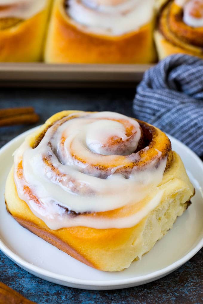 Cinnamon Rolls Recipe | Cinnamon Buns #cinnamon #rolls #pastry #breakfast #brunch #sweets #edsug #baking #bread A frosted cinnamon bun on a serving plate.
