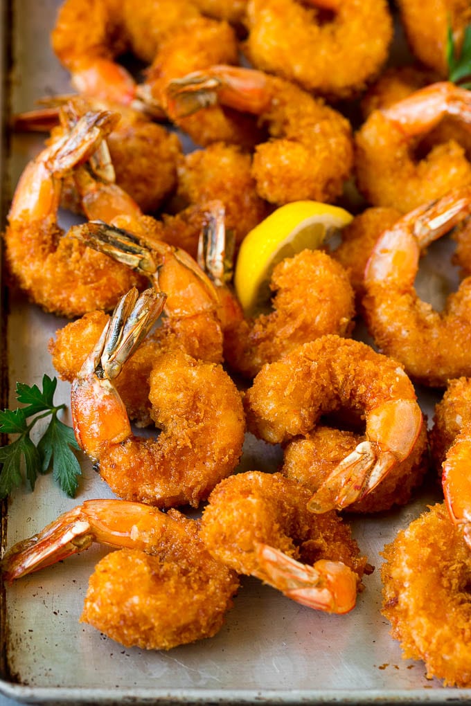 Fried Shrimp Recipe #shrimp #seafood #dinner #appetizer #edsug Fried shrimp on a sheet pan garnished with parsley and lemon.
