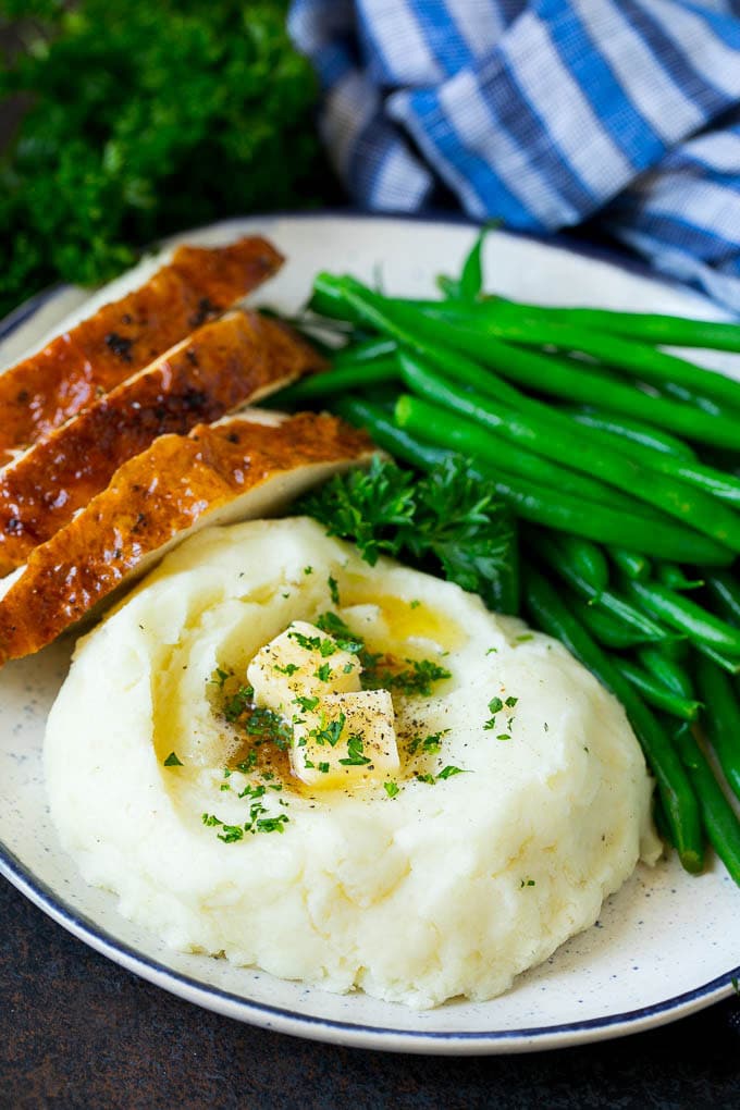 Garlic Mashed Potatoes Recipe #garlic #potatoes #mashedpotatoes #sidedish #dinner #thanksgiving #edsug A plate with garlic mashed potatoes, green beans and sliced turkey.