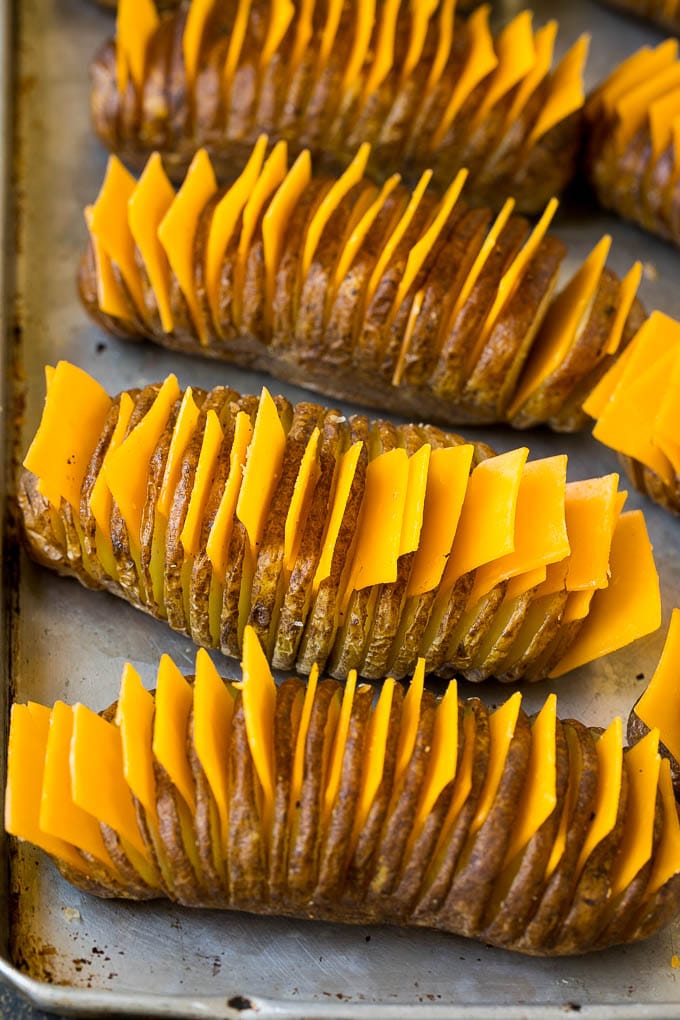 Hasselback Potatoes Recipe #potatoes #bacon #sidedish #cheese #dinner #edsug Thinly sliced potatoes with slices of cheese in between the cuts.