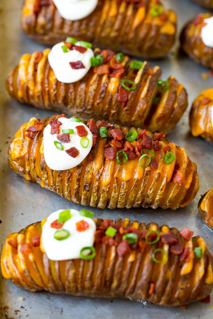 Hasselback Potatoes Recipe #potatoes #bacon #sidedish #cheese #dinner #edsug Hasselback potatoes filled with melted cheese, then topped with bacon, sour cream and green onions.