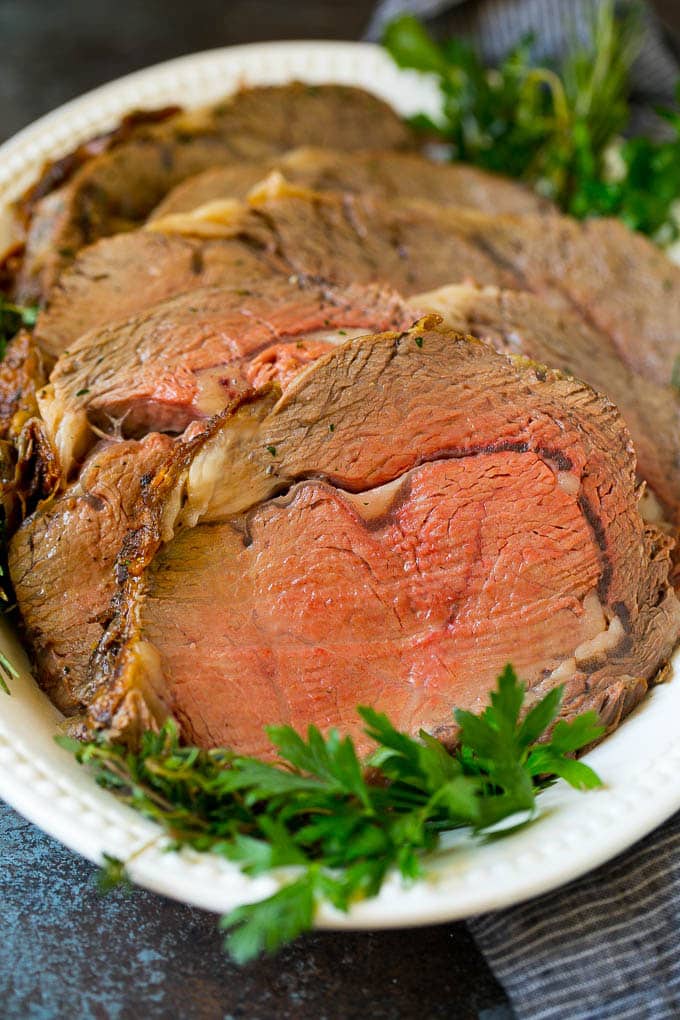 Prime Rib Recipe #primerib #beef #roast #dinner #thanksgiving #christmas #keto #lowcarb #edsug Sliced slow roasted prime beef on a serving platter.