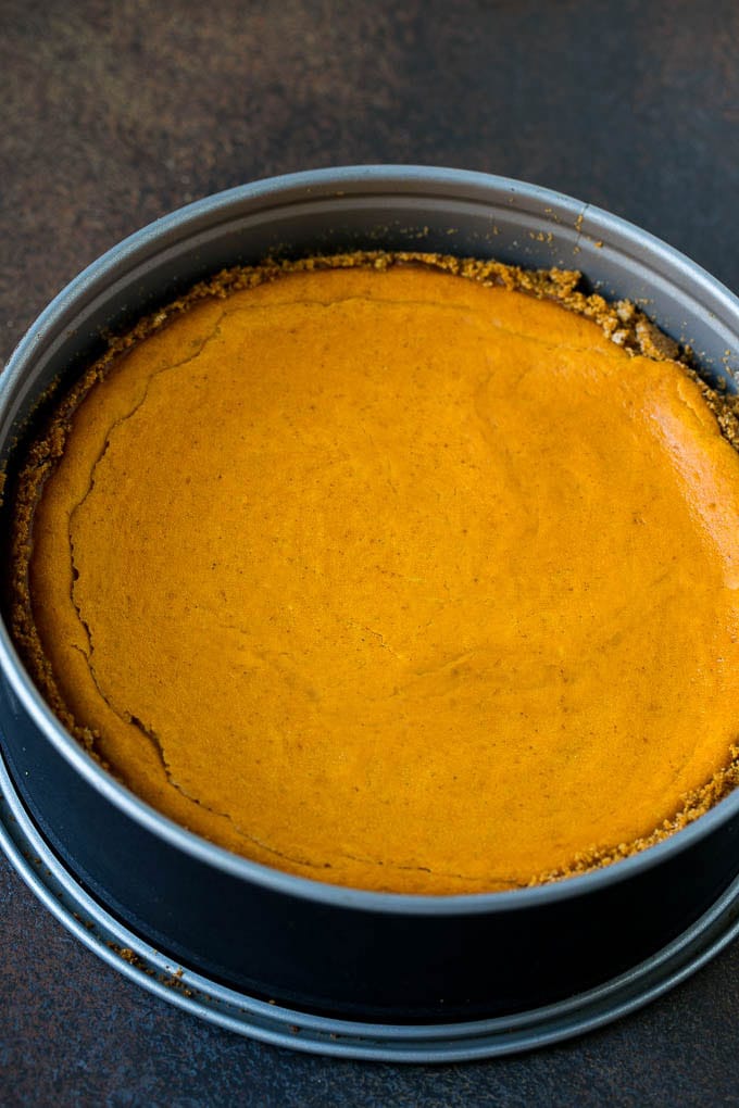 Pumpkin Pie Cheesecake Recipe | Pumpkin Cheesecake #cake #cheesecake #pumpkin #fall #thanksgiving #dessert #edsug A baked pumpkin cheesecake in a pan.