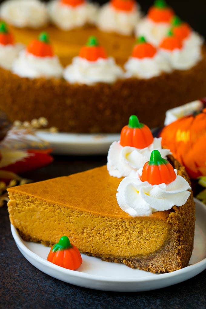 Pumpkin Pie Cheesecake Recipe | Pumpkin Cheesecake #cake #cheesecake #pumpkin #fall #thanksgiving #dessert #edsug A slice of pumpkin pie cheesecake garnished with whipped cream.