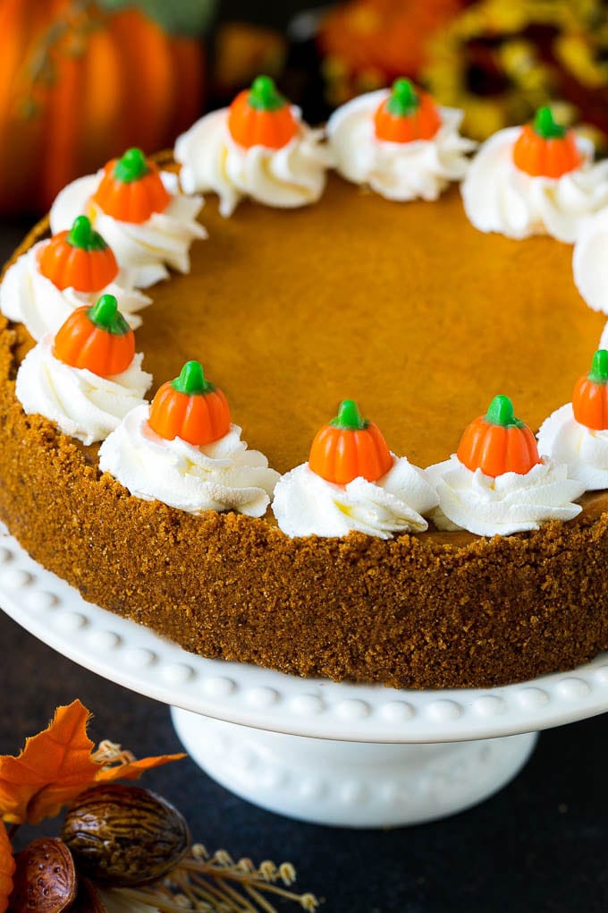Pumpkin Pie Cheesecake Recipe | Pumpkin Cheesecake #cake #cheesecake #pumpkin #fall #thanksgiving #dessert #edsug Pumpkin pie cheesecake topped with whipped cream and candy pumpkins.