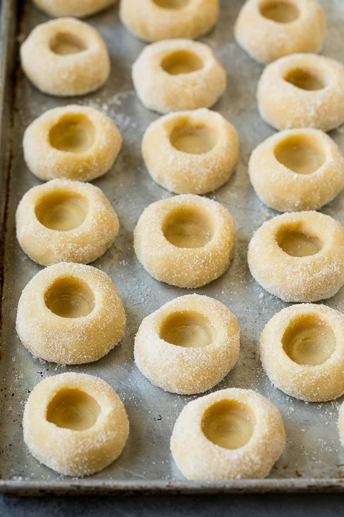 Thumbprint Cookies | Sugar Cookies #cookies #baking #christmas #dessert #edsug Balls of cookie dough with indentations in them.