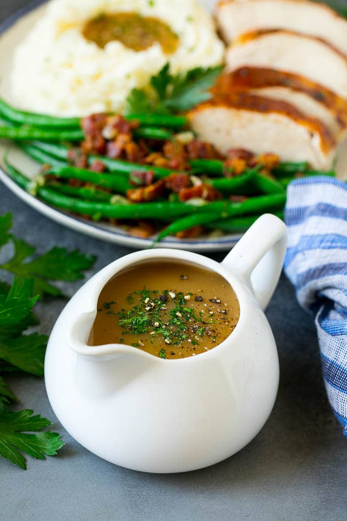This is the best turkey gravy you'll ever have - it's smooth, creamy and full of savory flavors. Homemade gravy is a must have for any holiday meal, and my version is so simple to make. A pitcher of turkey gravy garnished with fresh parsley.