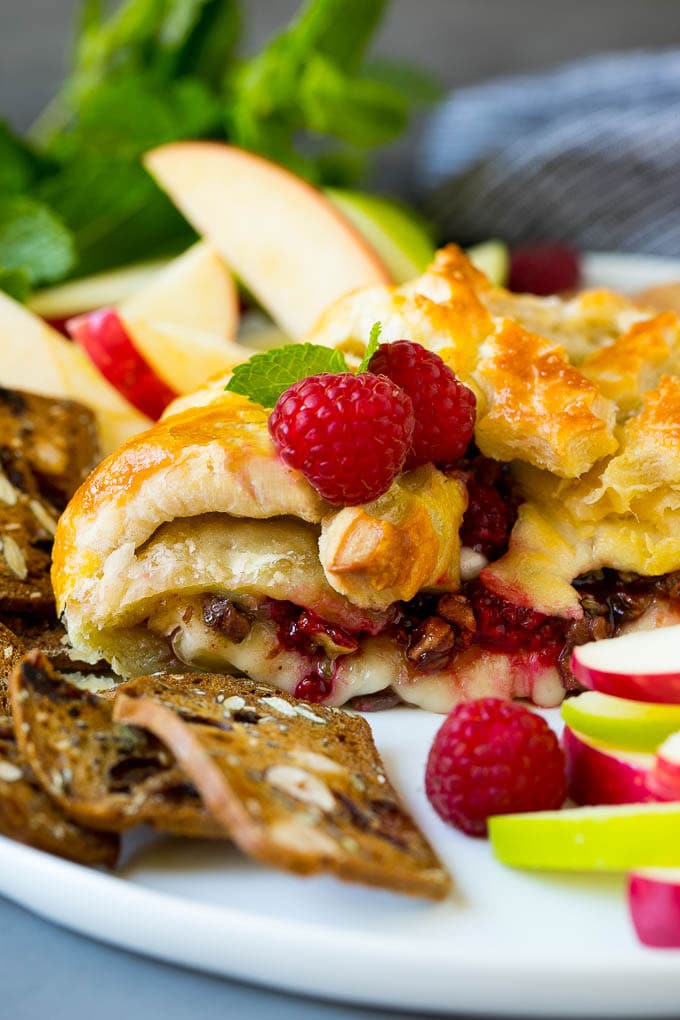 Baked Brie Recipe | Pastry Wrapped Brie #brie #cheese #appetizer #pecans #raspberries #edsug A cross section of baked brie filled with raspberries and pecans.