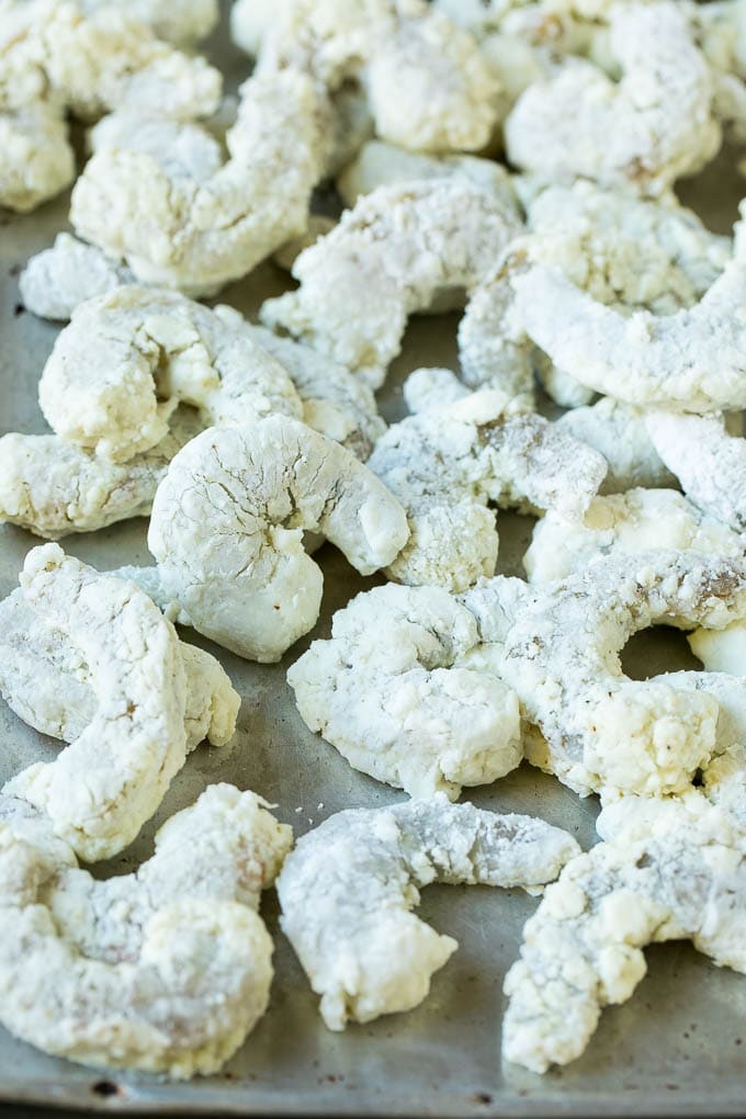 Bang Bang Shrimp Recipe | Fried Shrimp #shrimp #appetizer #dinner #edsug #copycatrecipe Shrimp coated in cornstarch on a sheet pan.