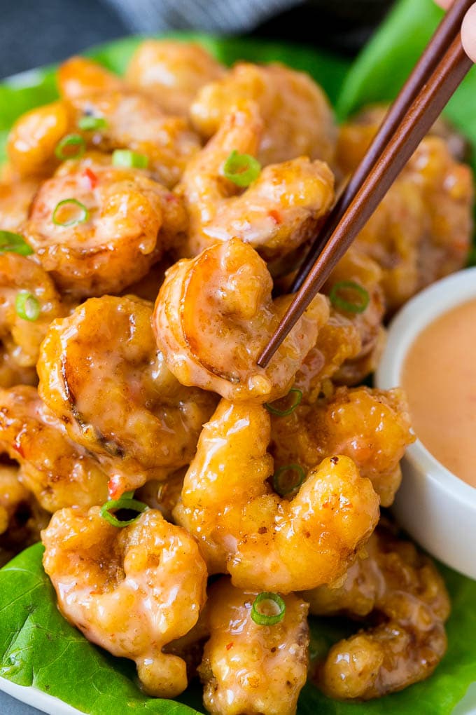 Bang Bang Shrimp Recipe | Fried Shrimp #shrimp #appetizer #dinner #edsug #copycatrecipe A pair of chopsticks picking up bang bang shrimp.