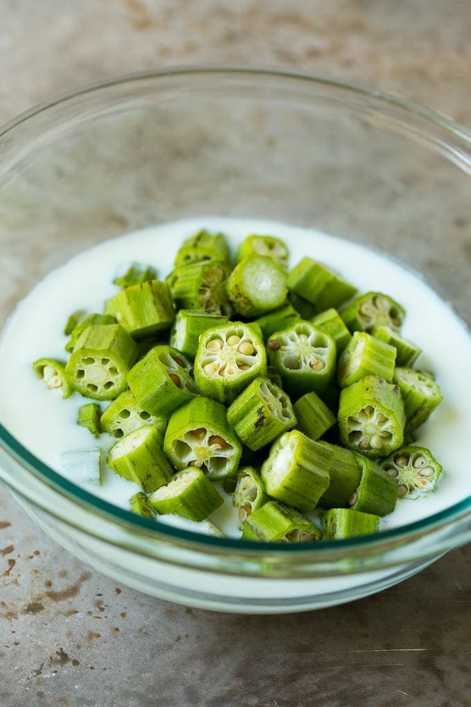 Fried Okra Recipe #okra #appetizer #sidedish #edsug Sliced okra in a bowl of buttermilk.
