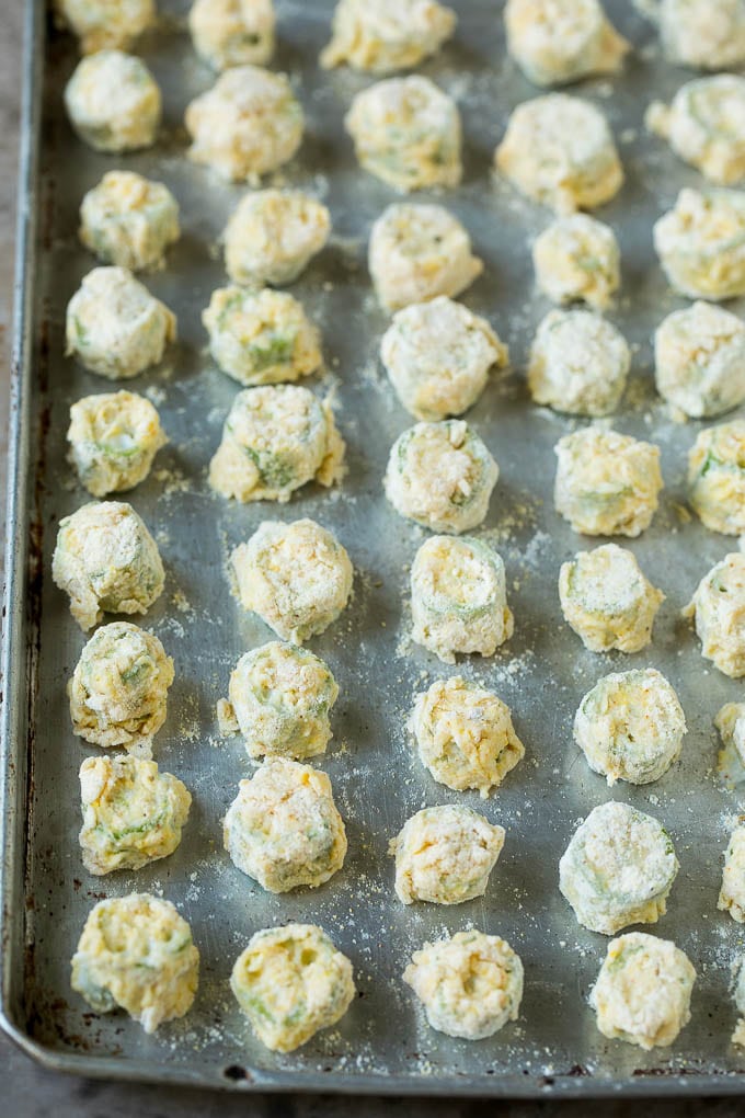 Fried Okra Recipe #okra #appetizer #sidedish #edsug Breaded okra slices on a sheet pan.