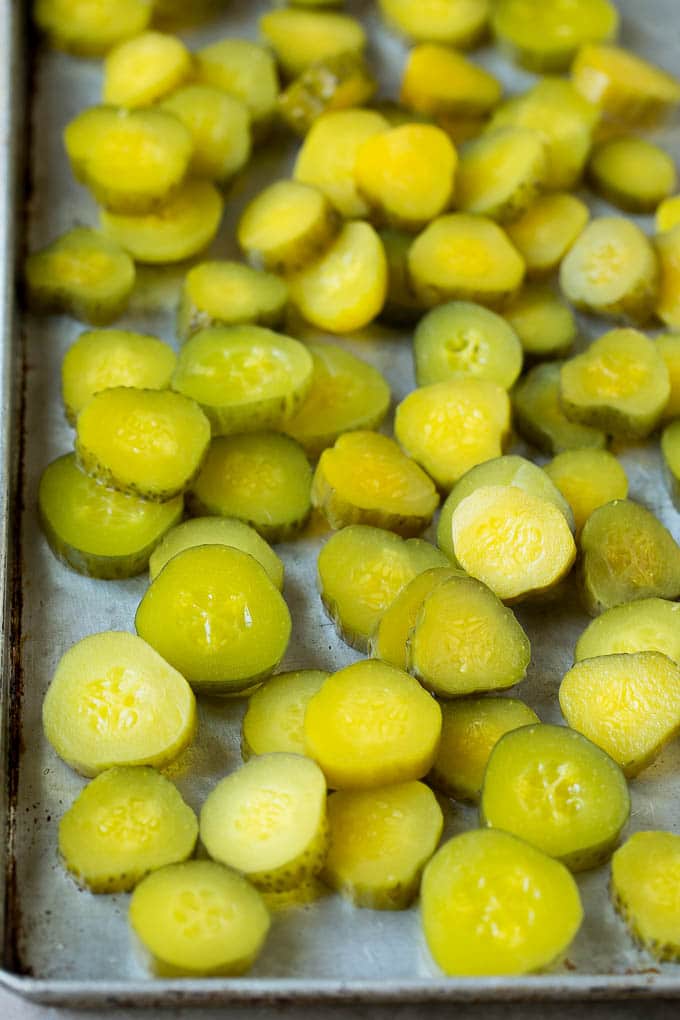 Fried Pickles Recipe #pickles #appetizer #snack #edsug Sliced dills on a sheet pan.