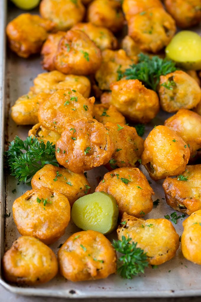 Fried Pickles Recipe #pickles #appetizer #snack #edsug Fried pickles on a sheet pan, garnished with parsley.